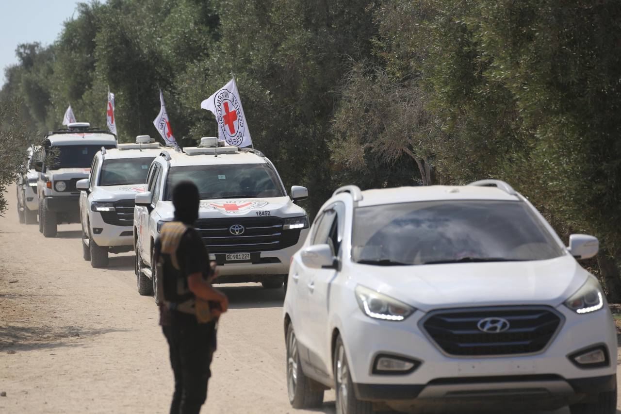 A Hamas member watched as released hostages were transported back to Israel this month. A Hamas member watched as released hostages were transported back to Israel this month.