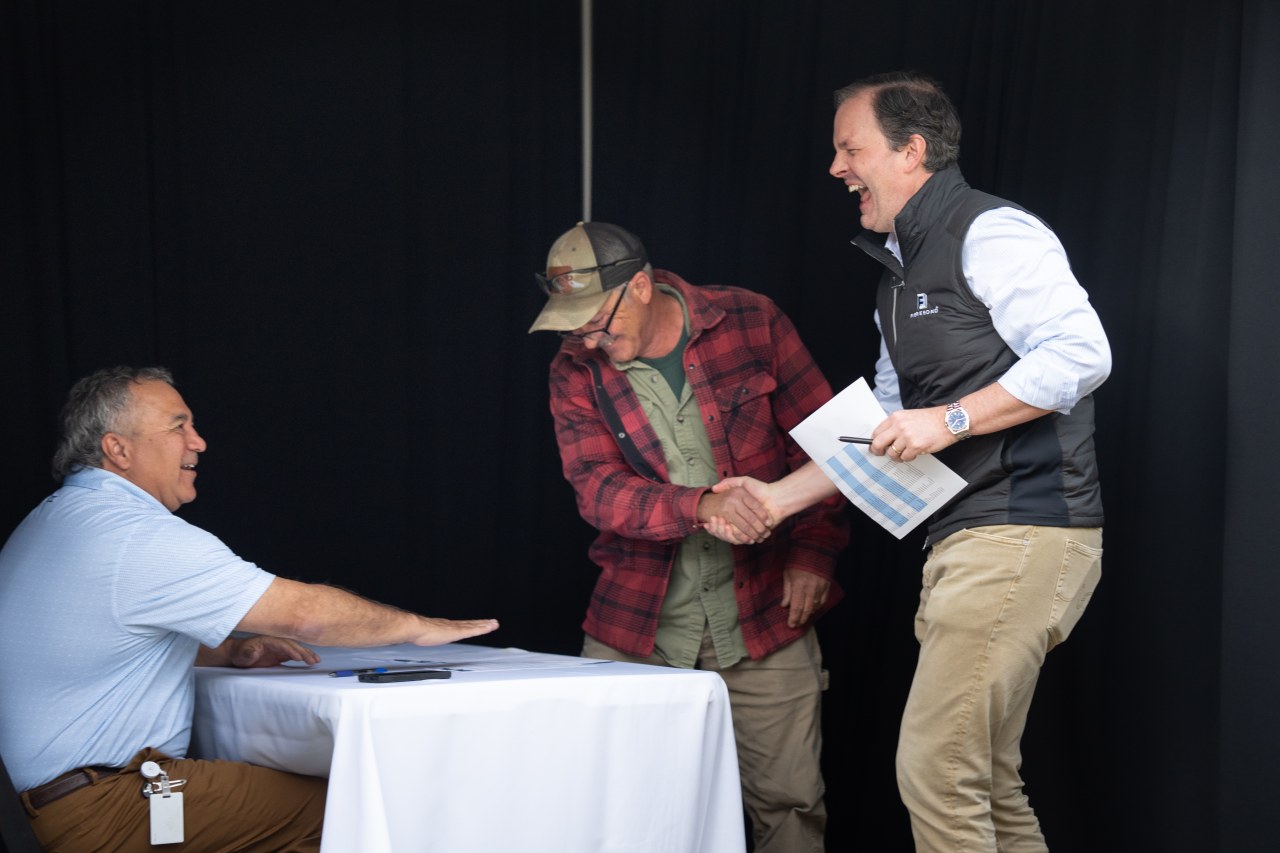 A Fibrebond employees shakes Walker’s hand as he learns the size of his bonus.