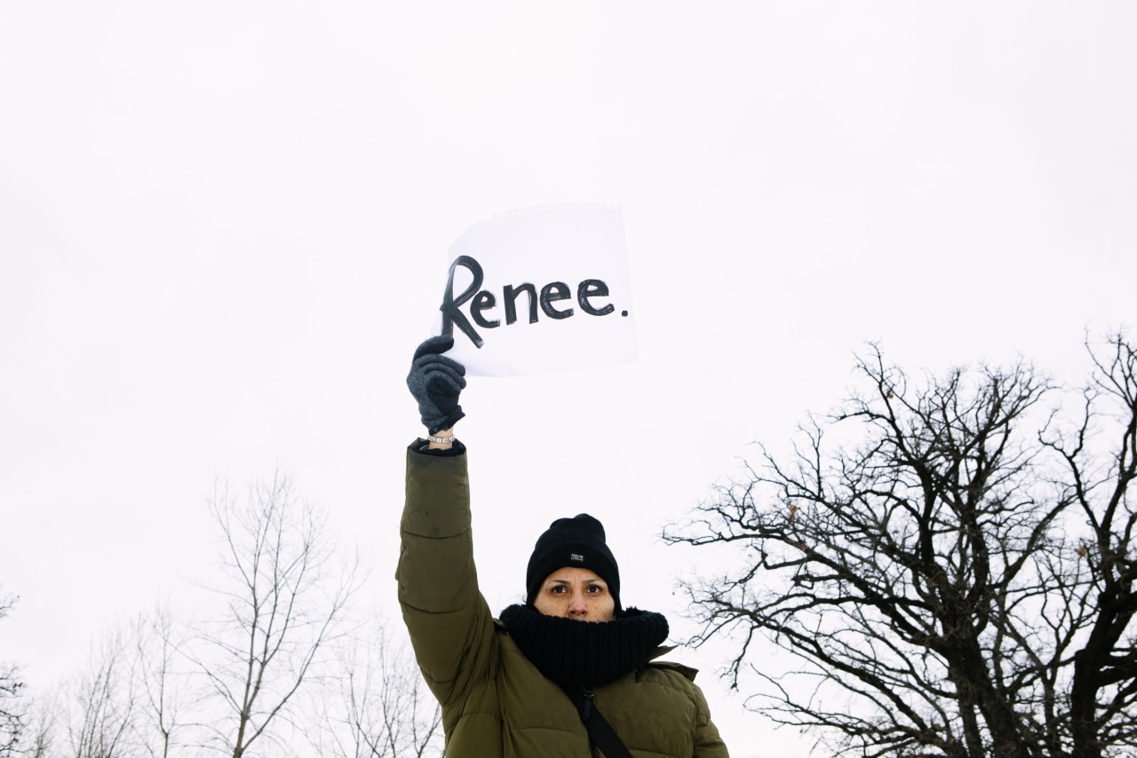 Lauren Johnson holds up a sign outside of the Whipple Building during a demonstration on Thursday.