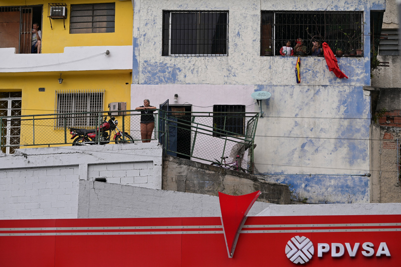 Venezuelans watch a protest march in Caracas calling for the release of the ousted president, Nicolás Maduro, with the logo of the state oil company in the foreground.