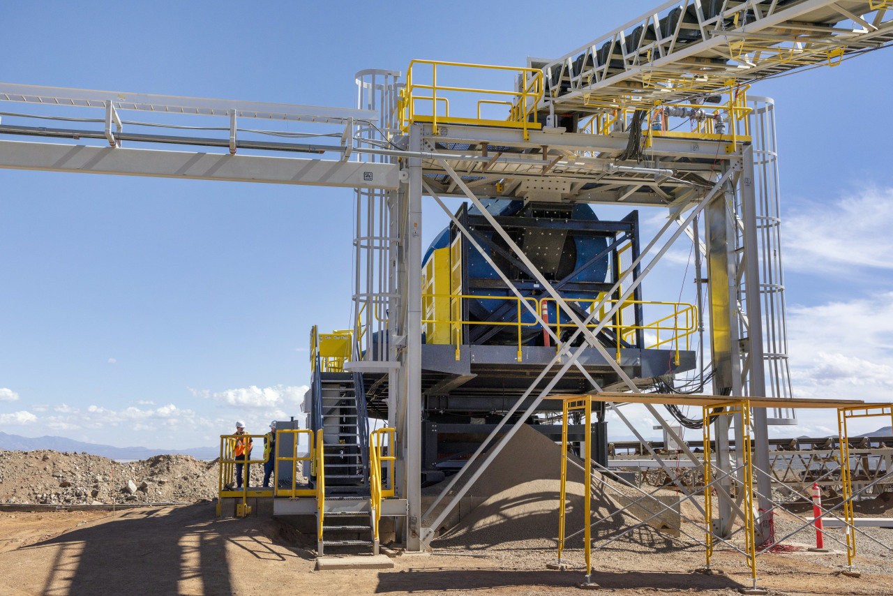 Ore is coated with bacteria and acid in an agglomerator before it is piled onto a leach pad, where a copper solution drips out.