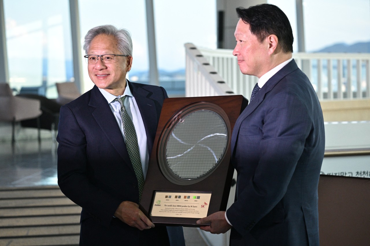 Jensen Huang&nbsp;receives a semiconductor wafer from&nbsp;Tae-Won Chey, the chairman of&nbsp;SK Hynix's parent company.