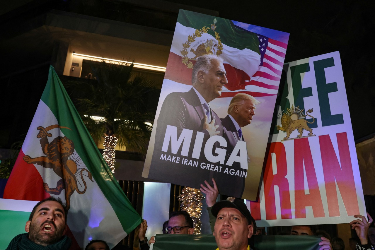 Protesters at the Iranian Embassy in Athens with a sign showing opposition figure Reza Pahlavi and President Trump.