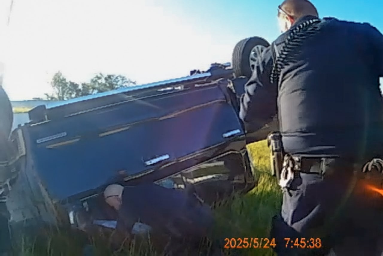 Police officers check on the Palepus in their overturned Ford F-150. Police officers check on the Palepus in their overturned Ford F-150.