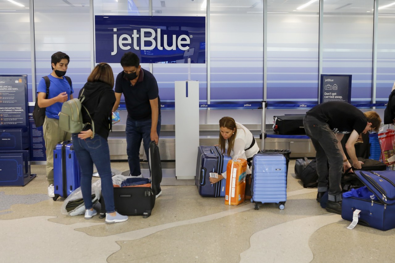 Travelers checking bags at a JetBlue counter in Fort Lauderdale, Fla.