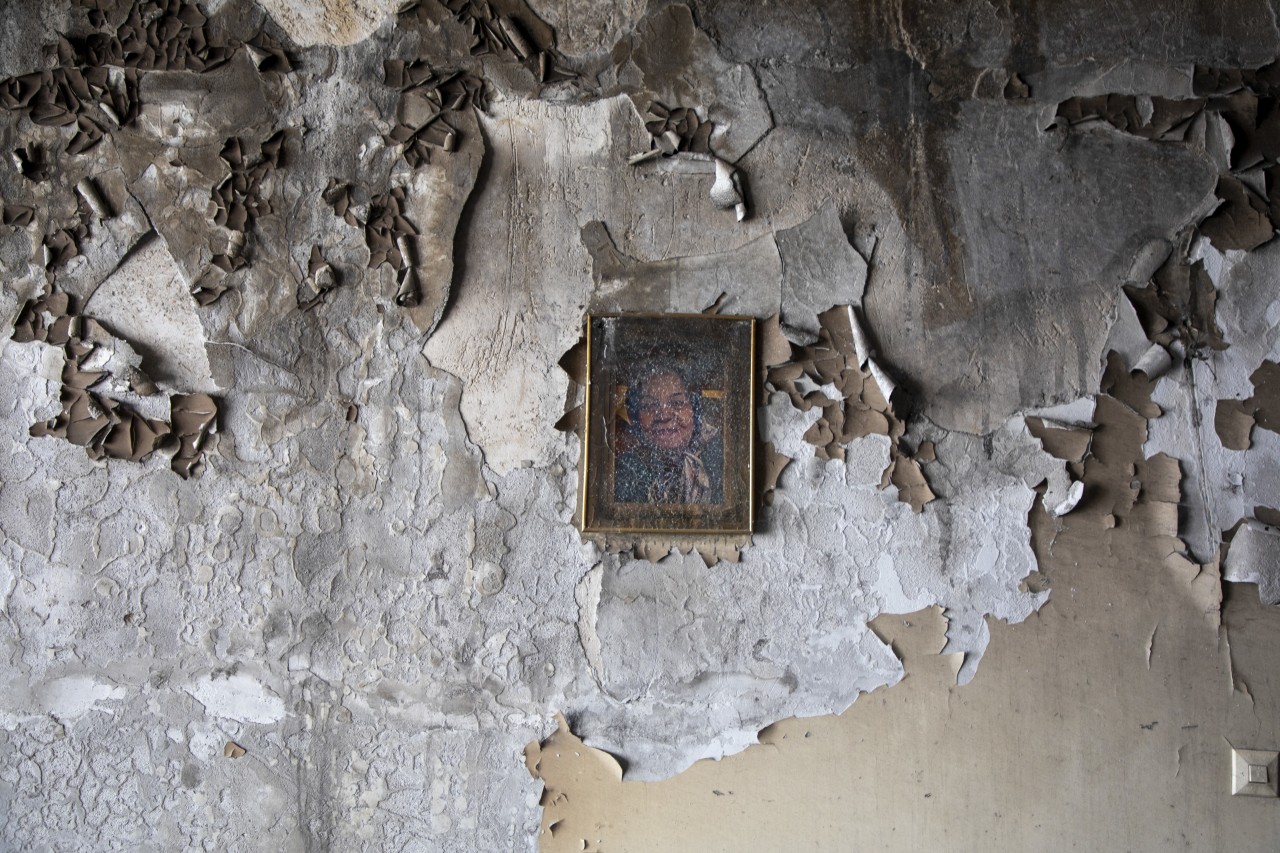 A picture hanging on a wall in a destroyed building in Tehran.