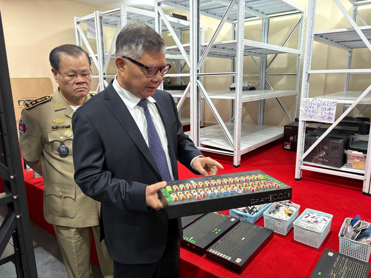 Chhay Sinarith, senior minister in charge of the Commission for Combating Online scams, inspecting evidence seized from scam compounds.